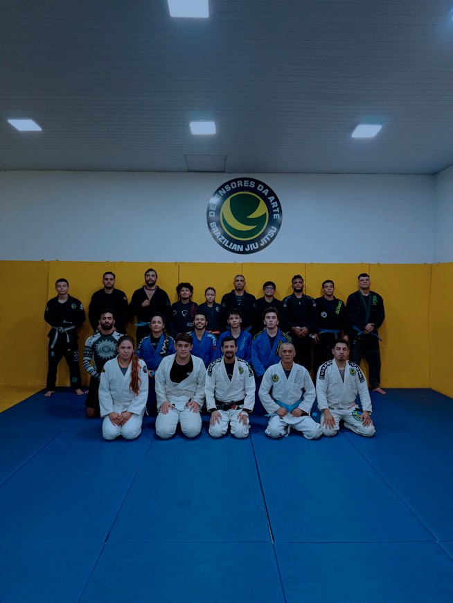Interior da academia com tatame azul e paredes amarelas